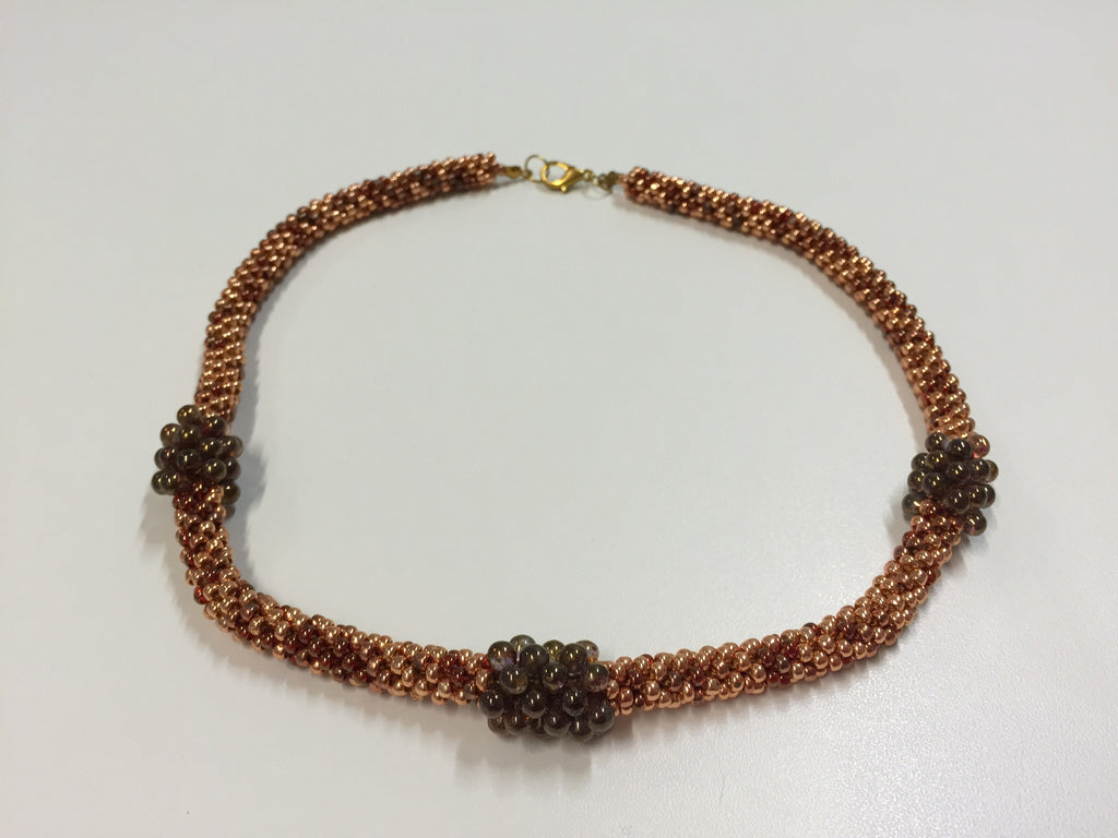 Beautiful gold-clasped necklace in bronze and gold with wine coloured treats